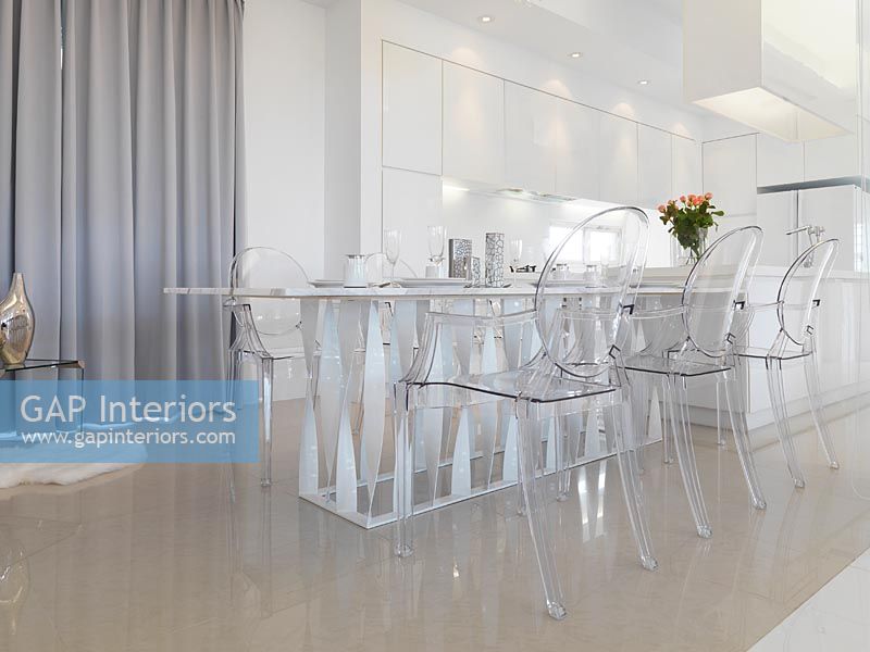 Low angle modern dining table with clear plastic chairs