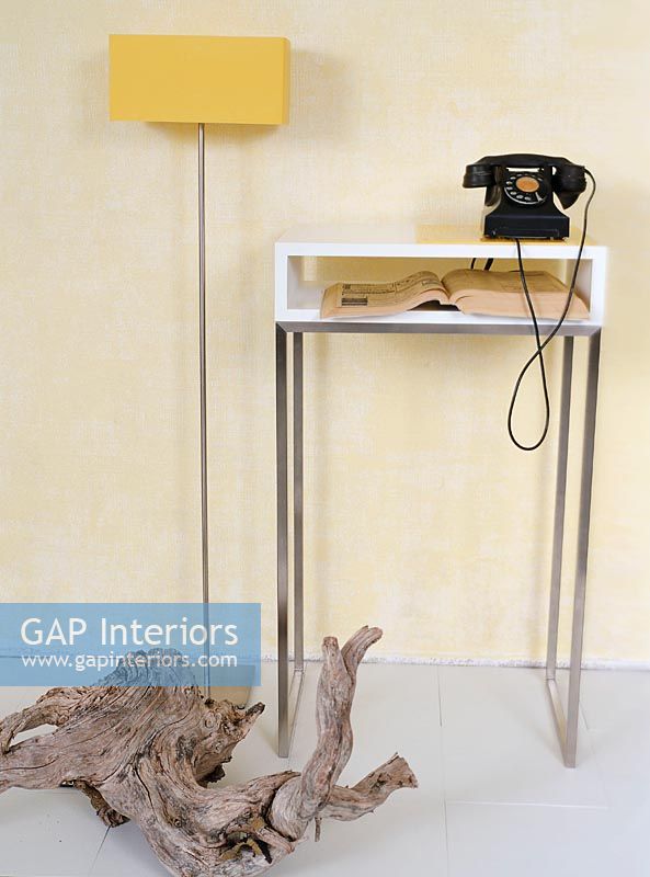 Small table with a vintage dial telephone and phonebook with driftwood
