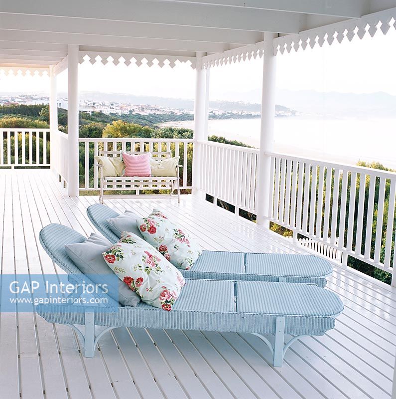 Two chaise lounges with pillows on balcony