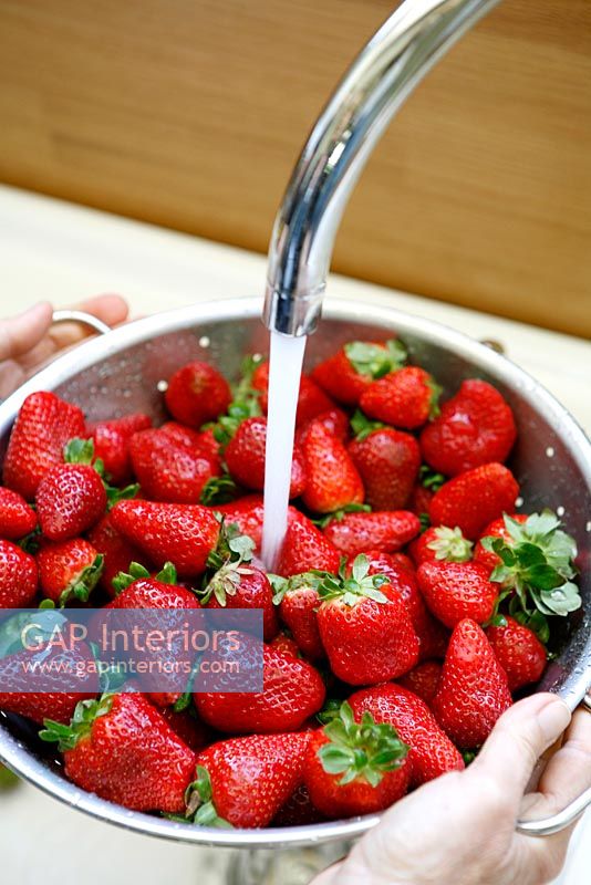 Strawberries being washed in sink