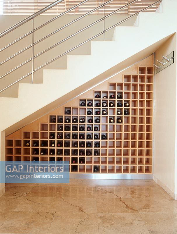 View of wine bottles on shelf under staircase