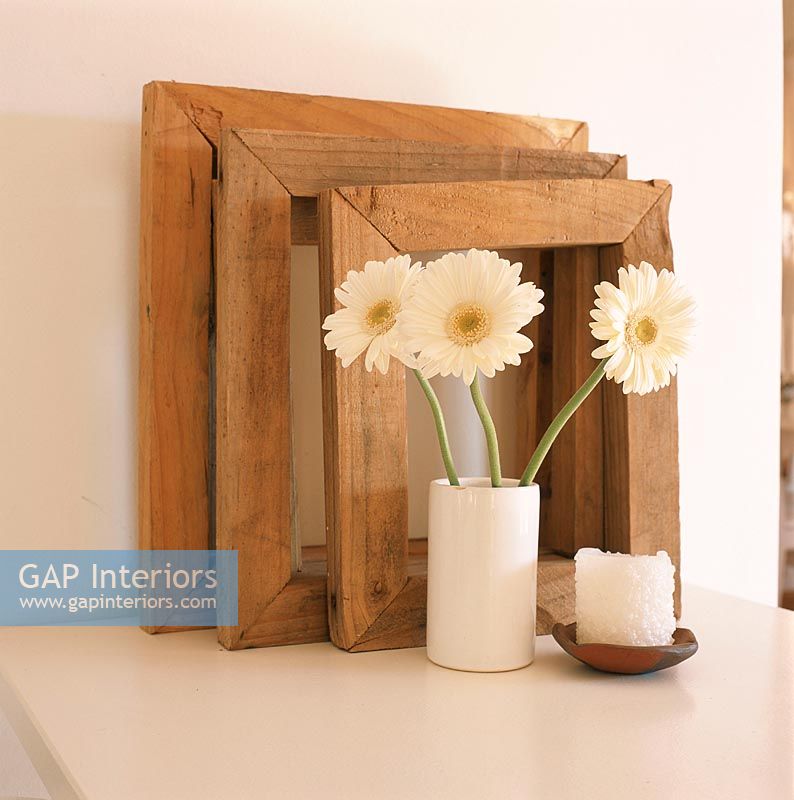 Wooden picture frames with flowers in vase
