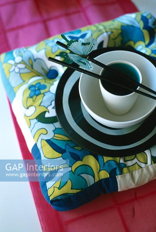 View of cup and bowl with chopstick on pillow