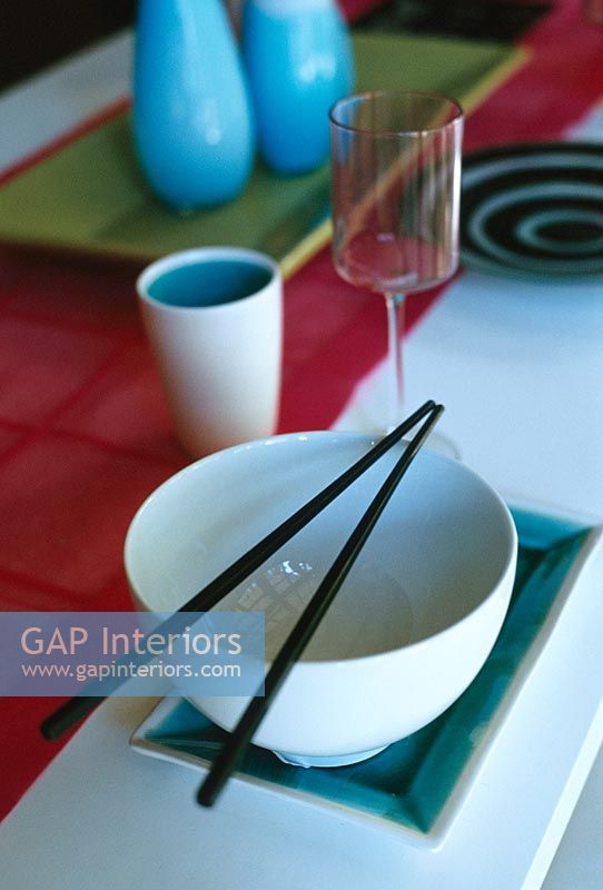 Bowl with chopsticks and glass, close-up