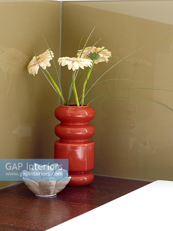 Gerberas in vase in modern bathroom