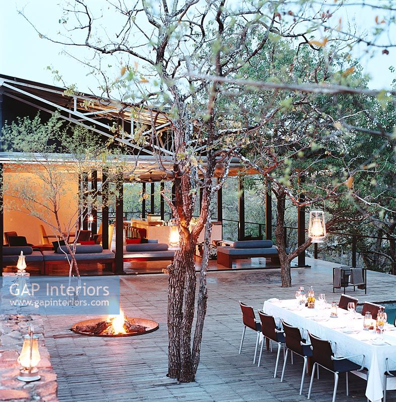 View of illuminated garden with dining table and fire pit