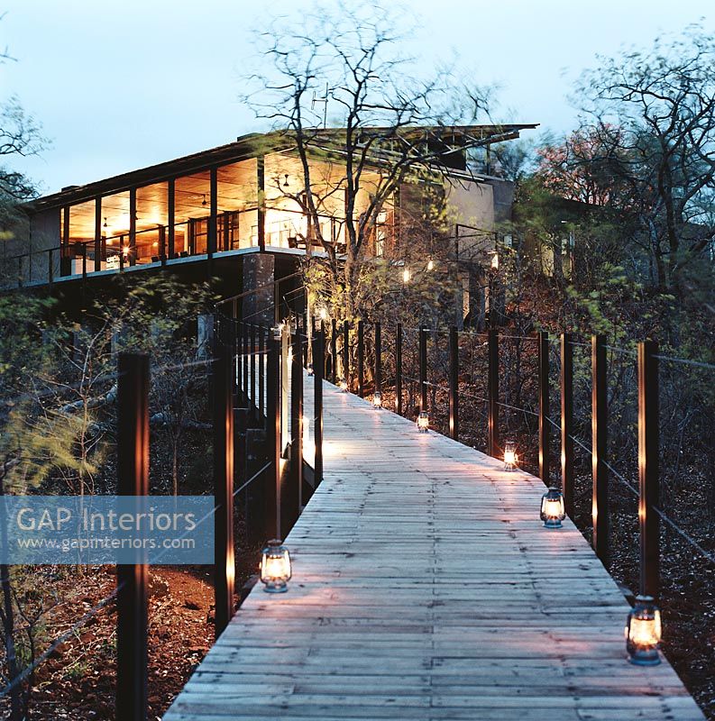 A contemporary facade and a wooden path with lanterns