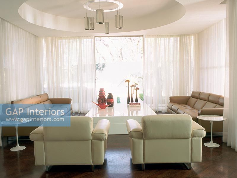 A contemporary living room with white curtains