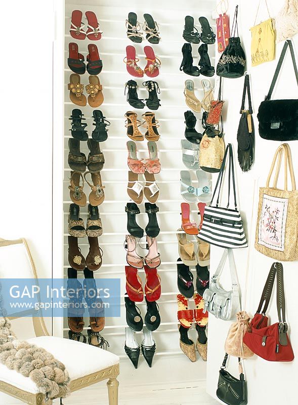 Shoes in rack and shopping bags hanging on wall