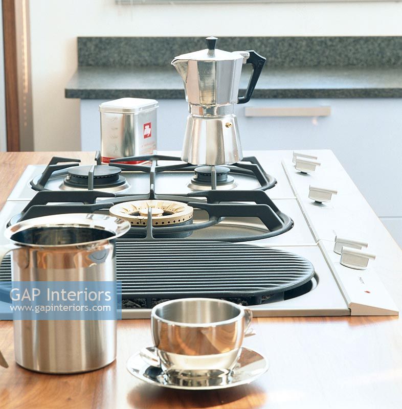 Stove top with coffee pot and silver cup