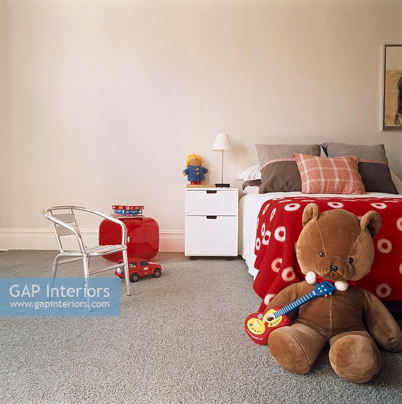 Child's bedroom with teddy bear and grey carpet