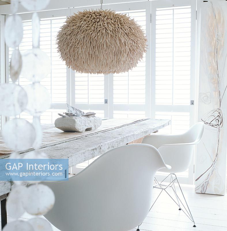 Chairs and a dining table with a fur covered hanging lamp