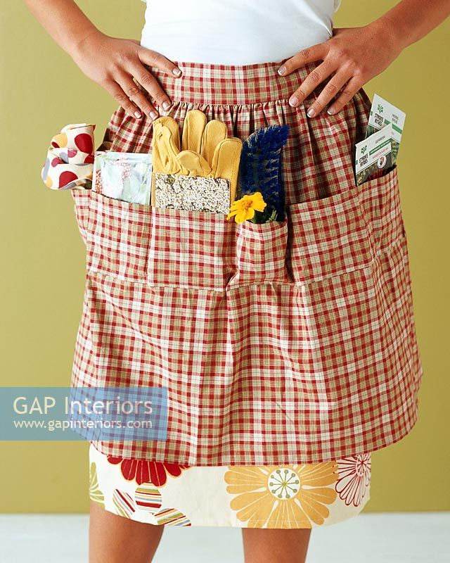 Woman wearing gardening apron, mid section
