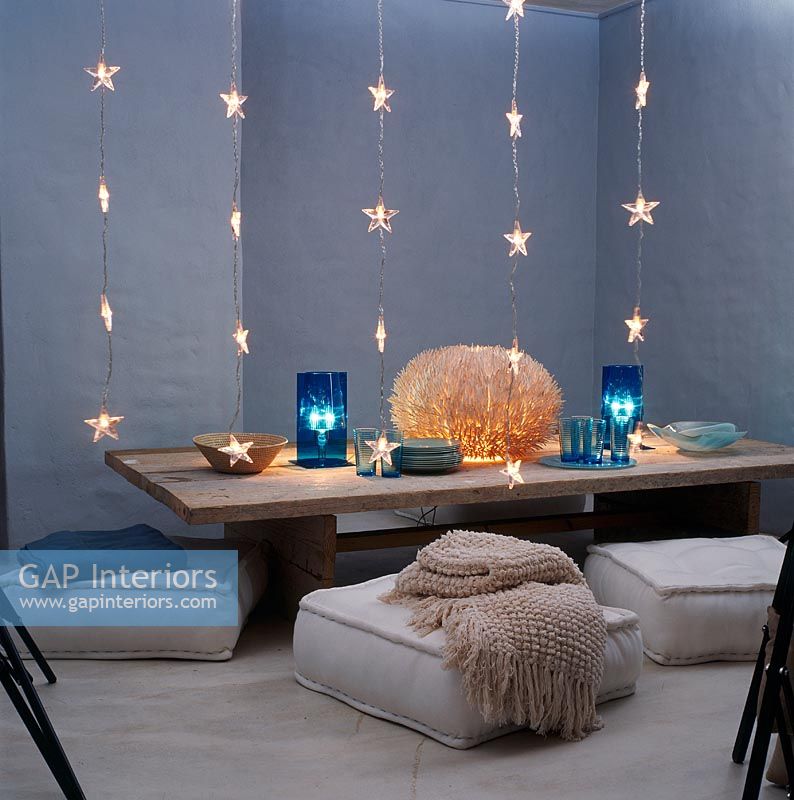 Low dining table with cushions and strands of star shaped lights