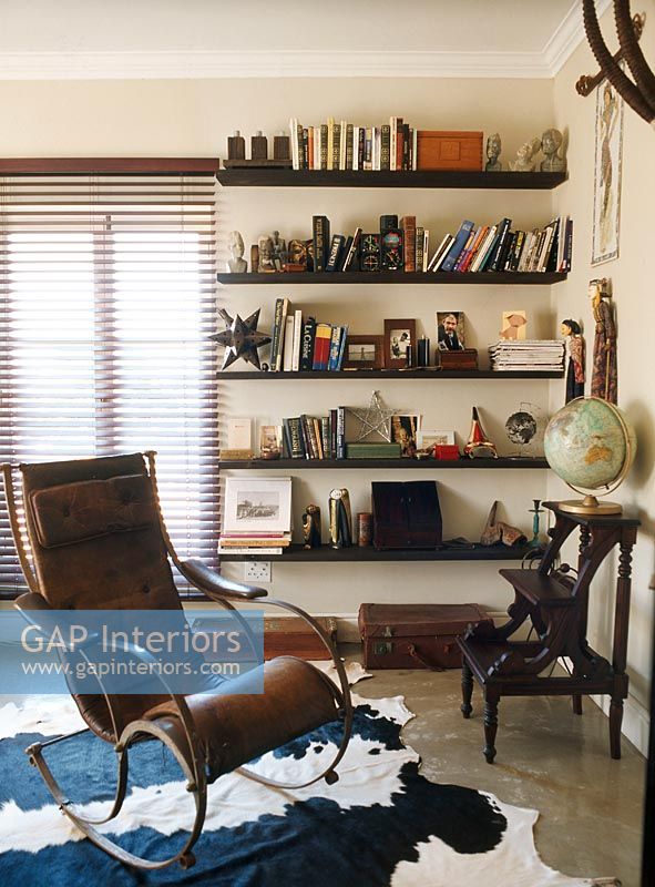 A brown leather armchair and a library