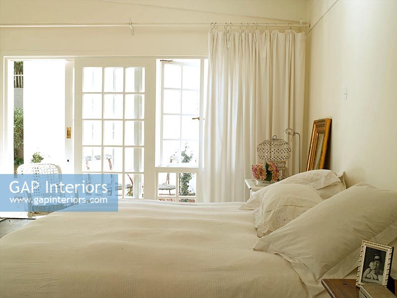 A white bedroom with a big window