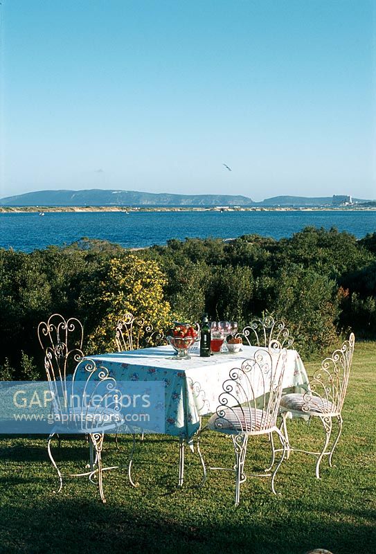Dining table on a lawn with a lake view