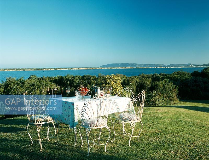 Dining table on a lawn with a lake view