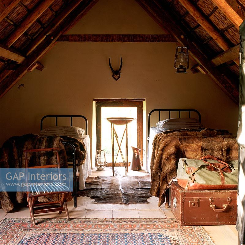 An attic bedroom with animal skin throws