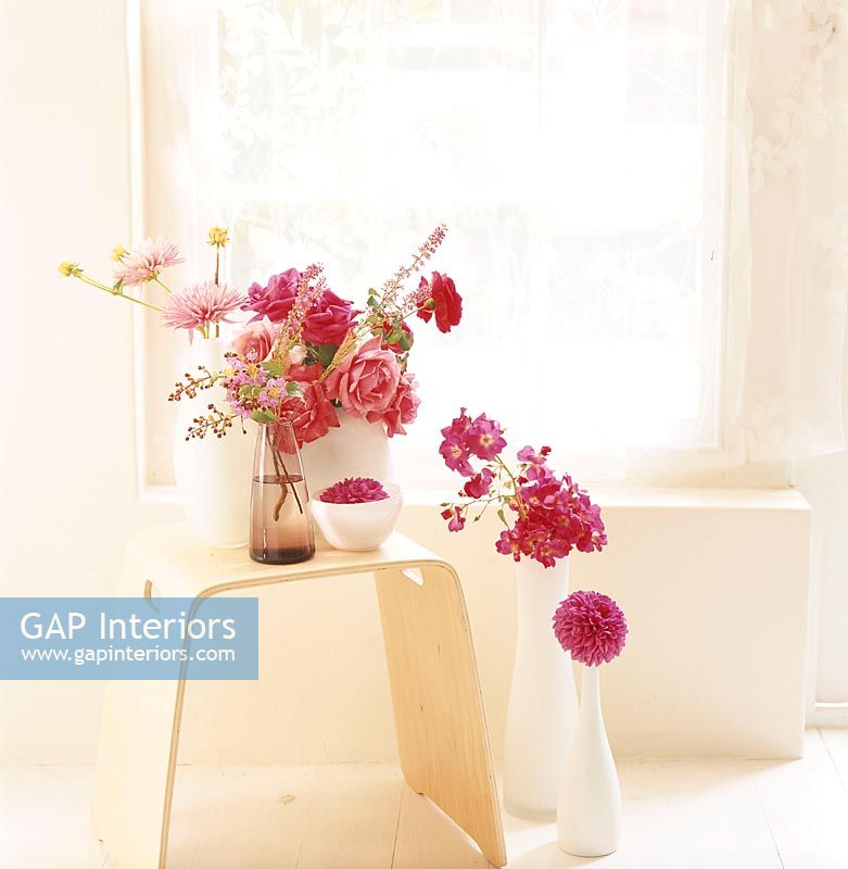 A collection of flower bouquets on a wooden stool