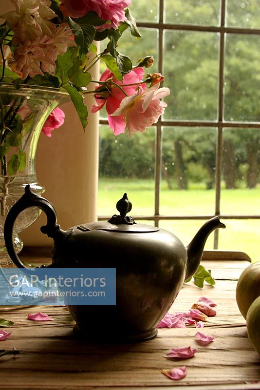 Teapot and vase of Roses on windowsill
