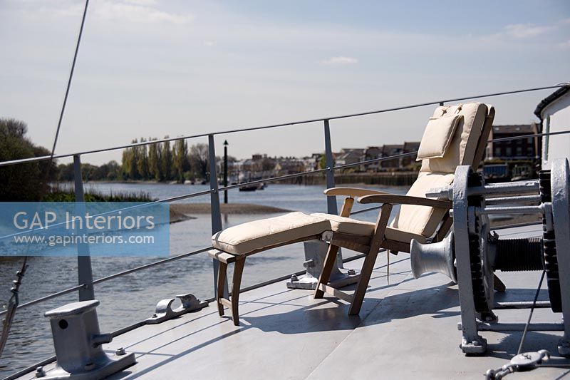 Sun lounger on deck of modern houseboat 