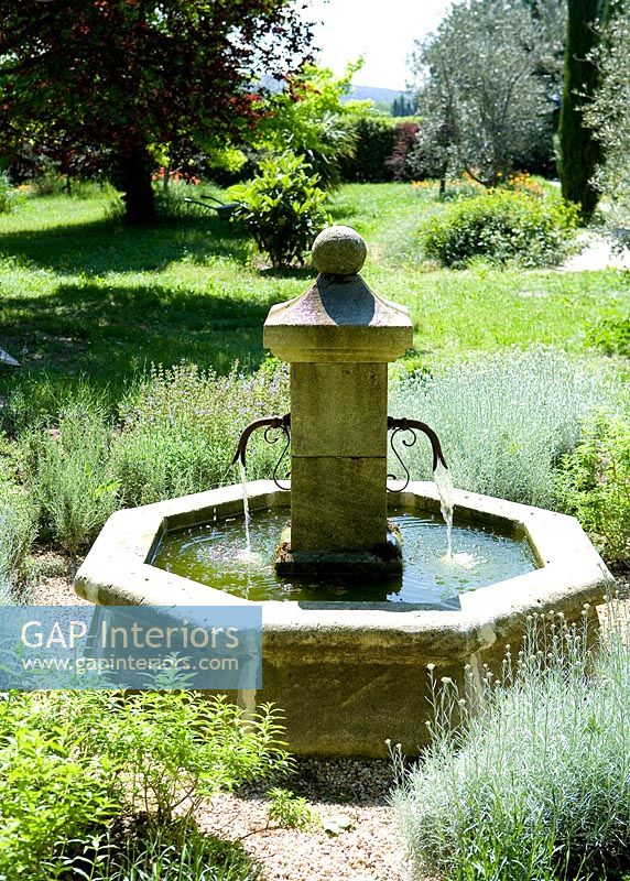 Traditional stone water well in country garden