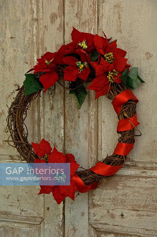 Poinsettia wreath on distressed door.