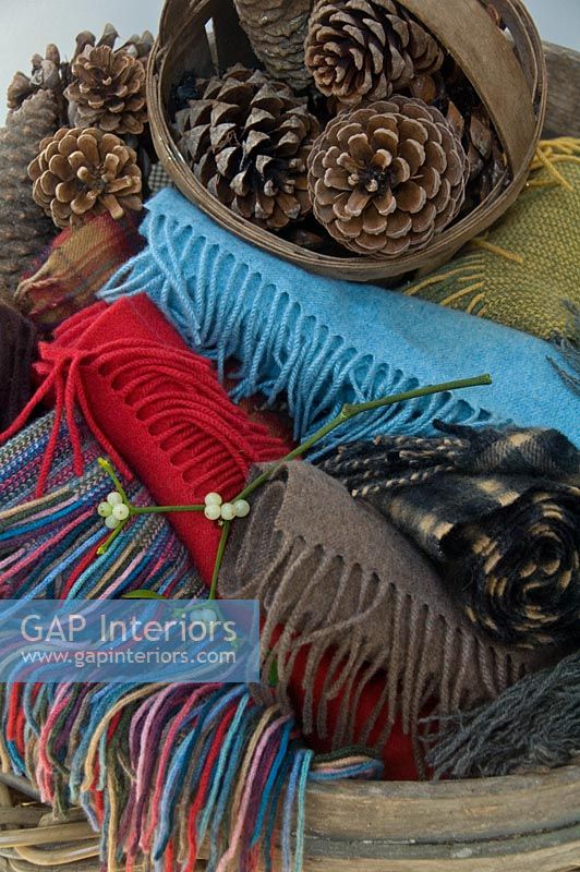 Detail of basket of scarves and pine cones 
