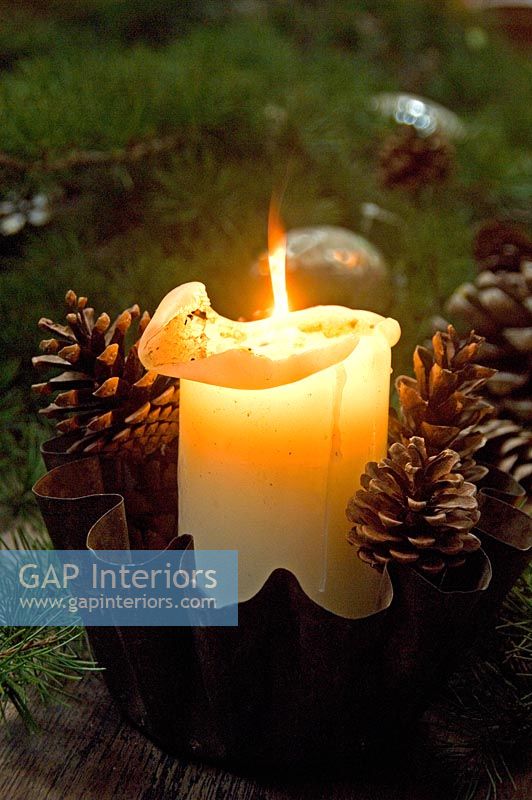 Church candle and decorative pine cones