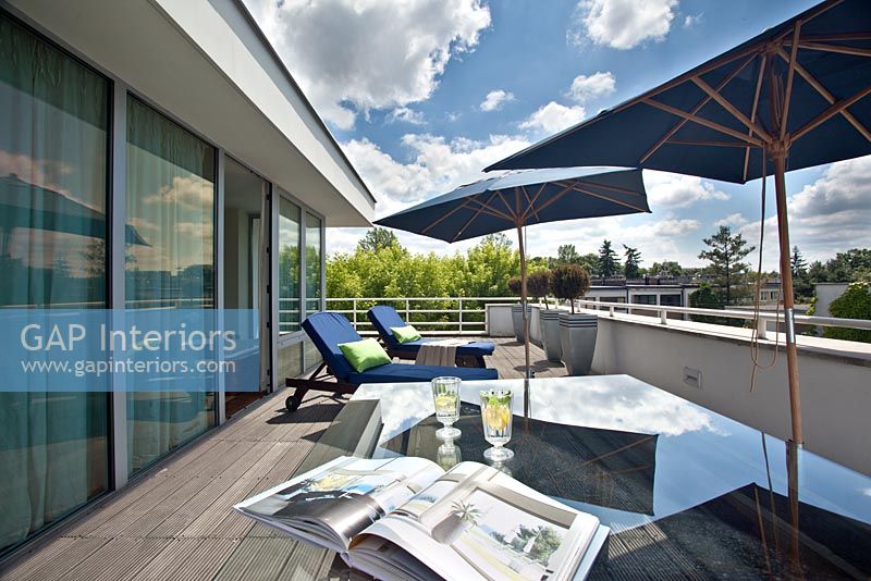 Modern sun loungers on balcony