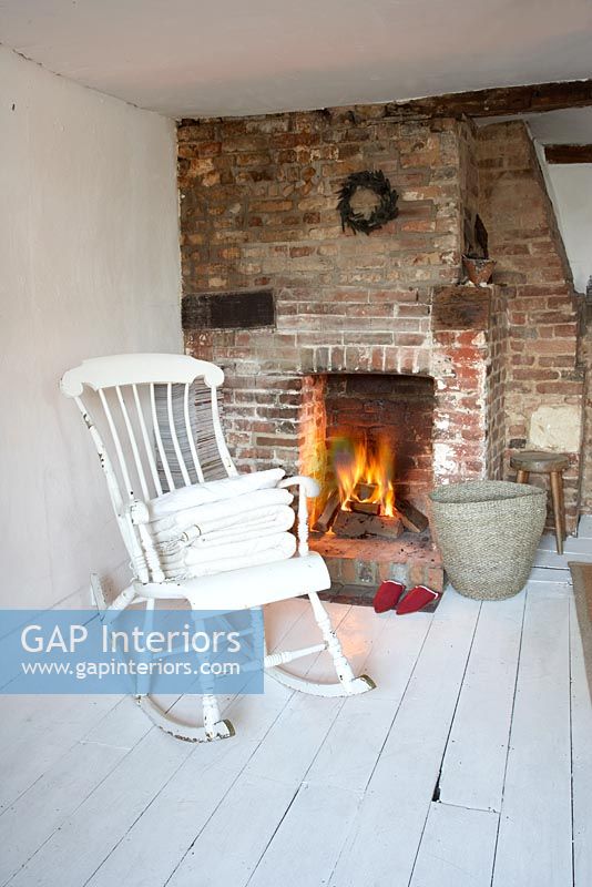 White rocking chair by fireplace