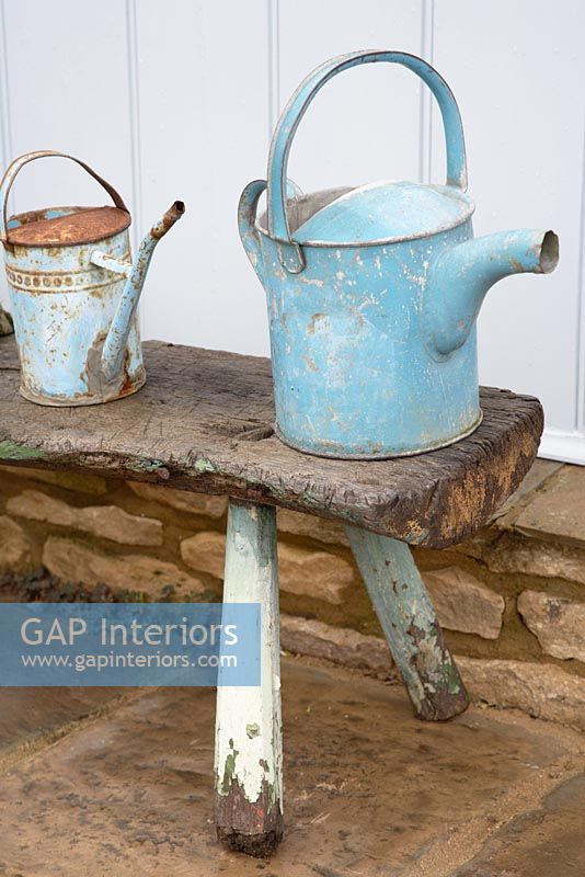 Vintage watering cans on garden table