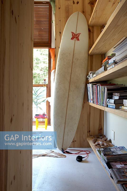 Surfboard next to shelves