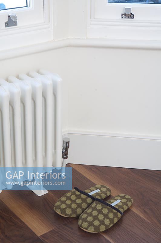 Radiator and slippers in modern bedroom 