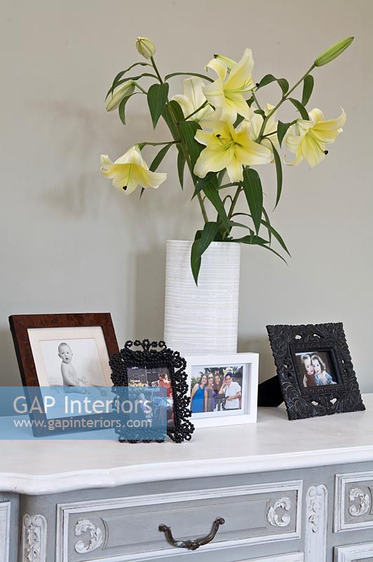 Family photographs and flowers on sideboard