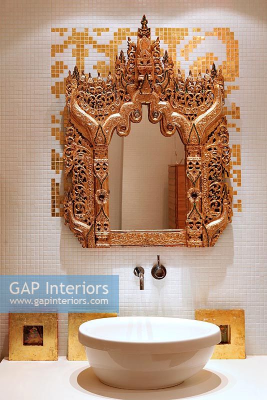 Modern bathroom sink and ornate mirror 