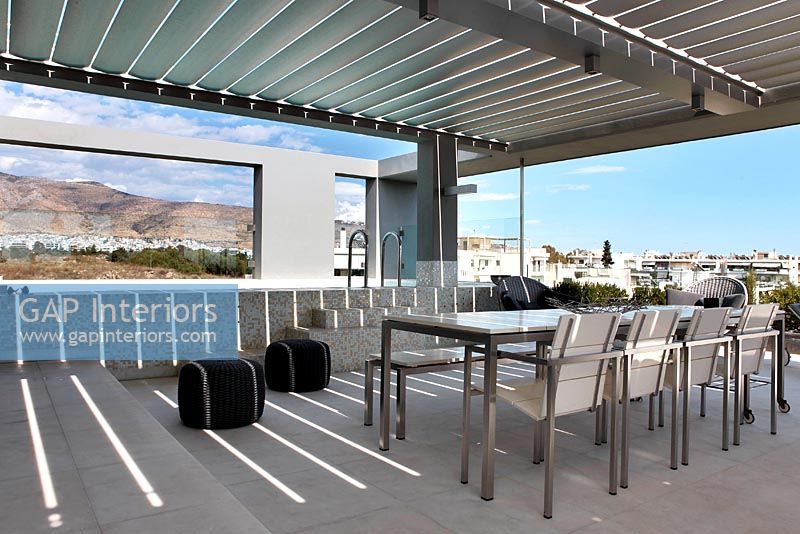Dining table and chairs on covered roof terrace