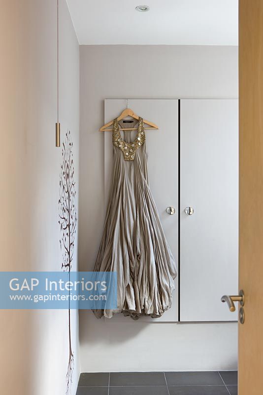 Satin dress hanging from built in cupboard in bathroom