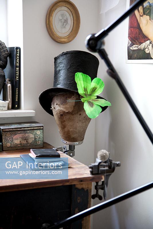 Top hat with butterfly ornament on corner of wooden desk
