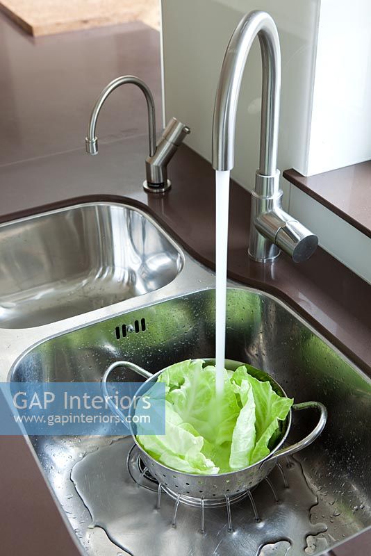 Rinsing lettuce in kitchen sink