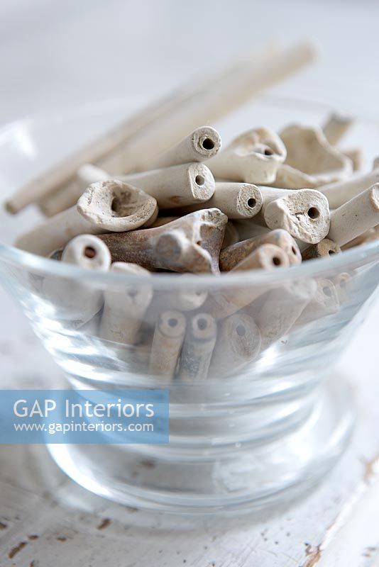 Collection of clay pipes in glass bowl, detail
