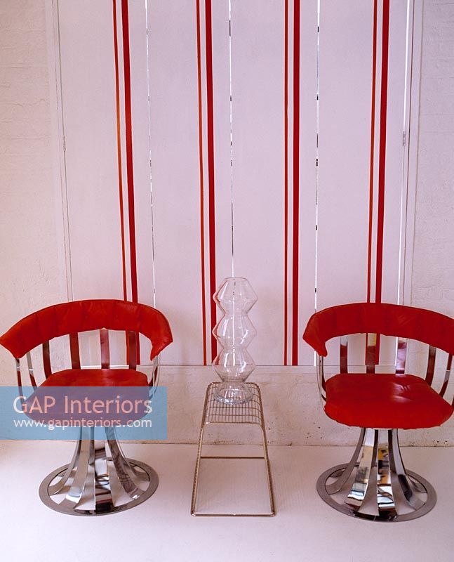 Red retro chairs and striped wallpaper