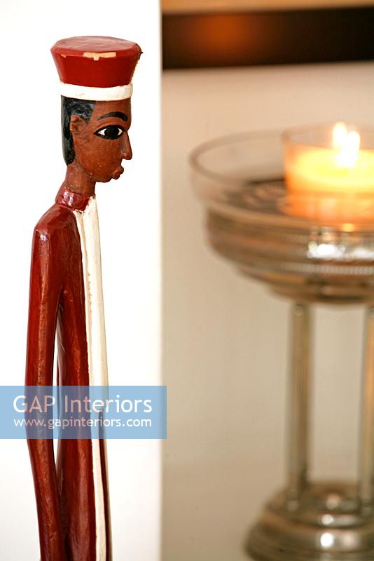 Wooden figurine against white wall