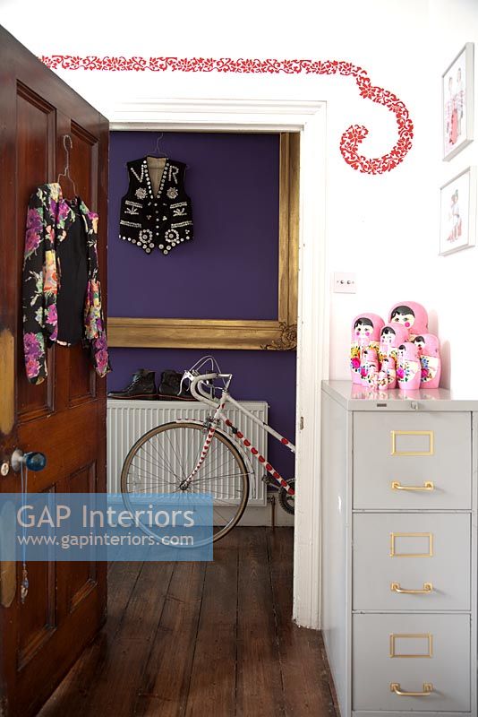 Door to colourful hallway with bicycle
