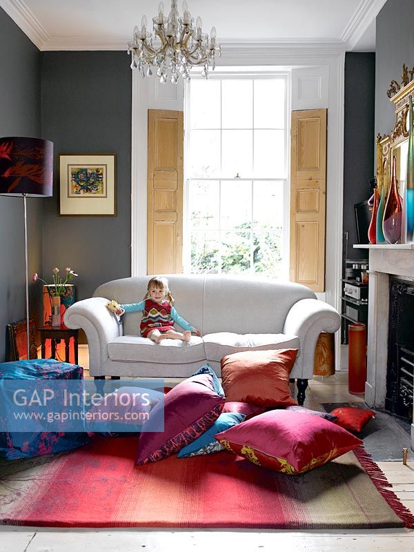 Child sitting on sofa in colourful living room
