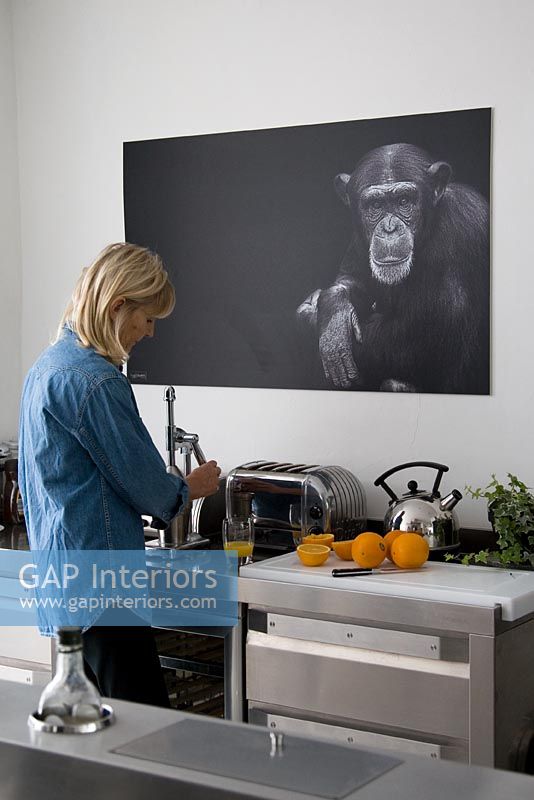 Woman using juicer in contemporary kitchen
