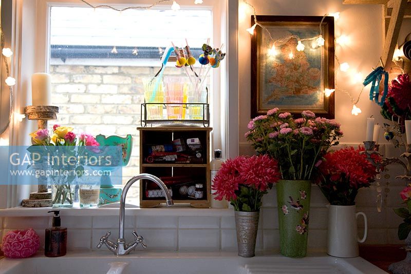 Flowers and fairy lights around kitchen sink 
