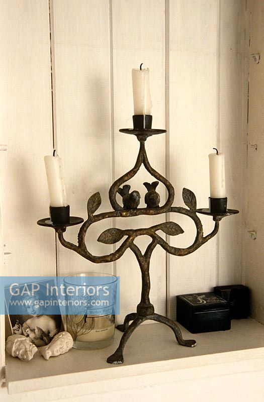 Ornate candelabra on wooden shelf