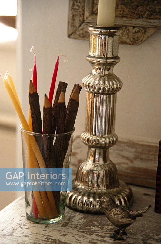 Silver candle stick and pencils in glass